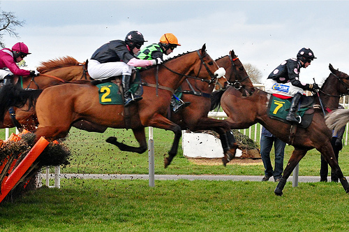 Horses jump a fence at Aintree