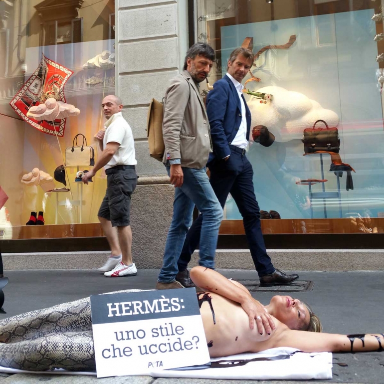 PETA supporters poses as reptile outside Hermes store in Italy