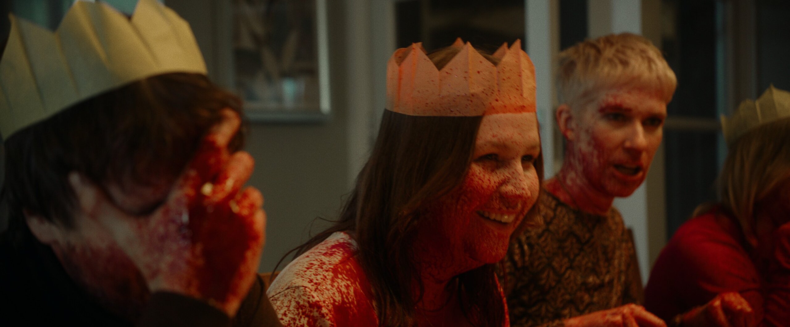 A family sitting round a Christmas table covered in fake blood