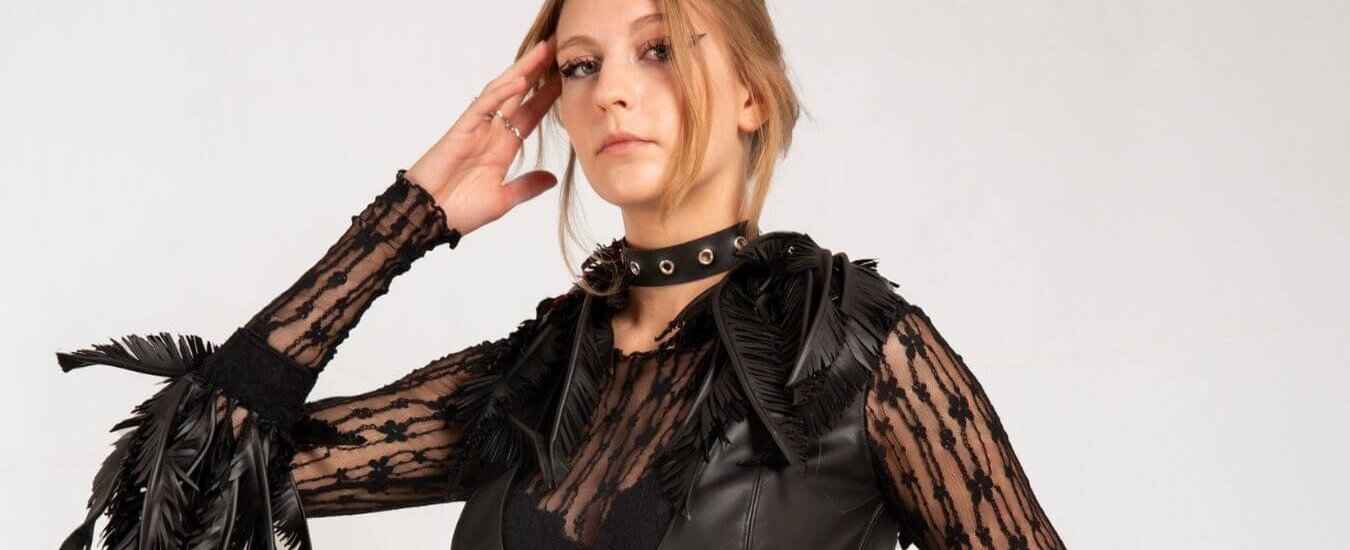 A model dressed in a black outfit complete with cruelty-free feathers
