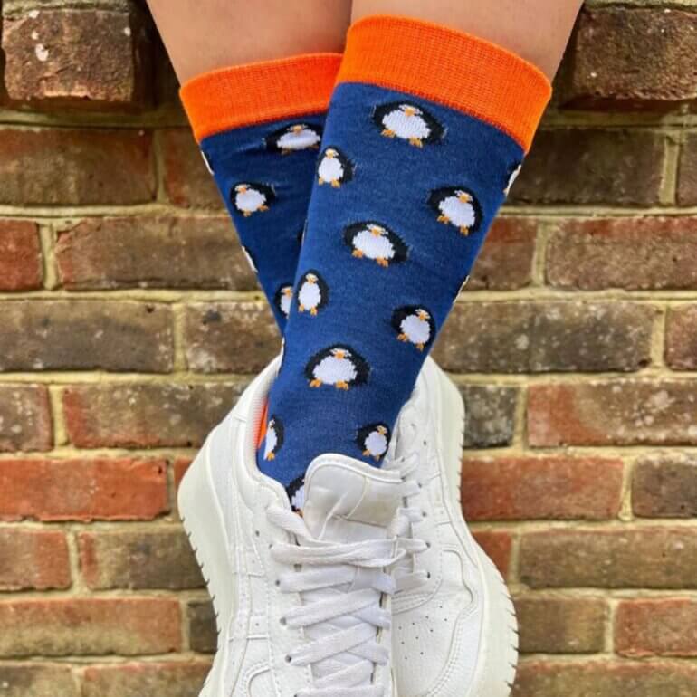 A close-up shot of some feet wearing bamboo vegan socks in front of a brick wall