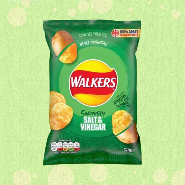 A packet of vegan Salt and Vinegar crisps from Walkers in front of a green background