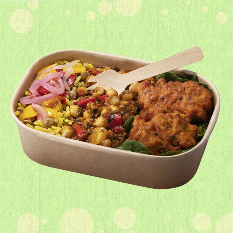 A sweet potato and onion bhaji rice bowl from Greggs vegan menu in front of a green background