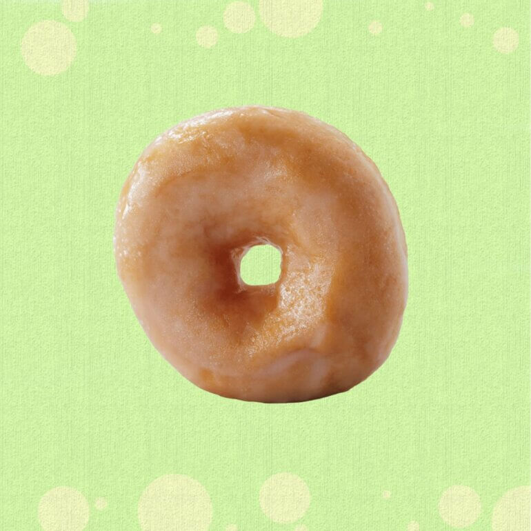 A ring doughnut from the Greggs vegan menu 2026 in front of a green background