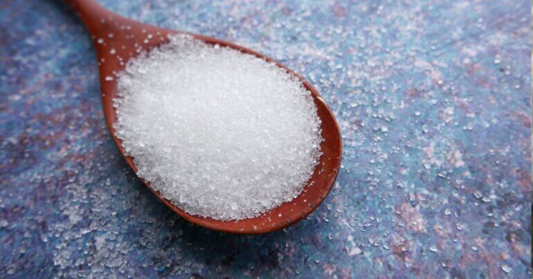 A spoon containing white sugar
