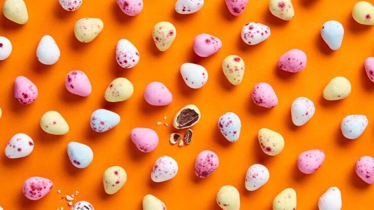A selection of vegan mini eggs in front of an orange background