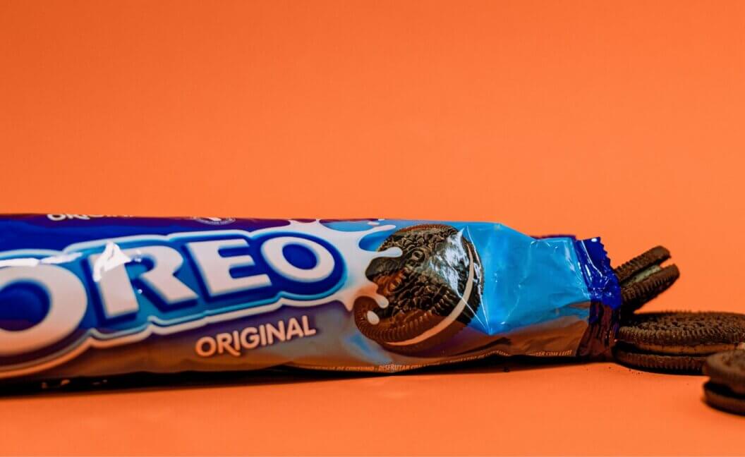 A packet of vegan Oreos in front of an orange background