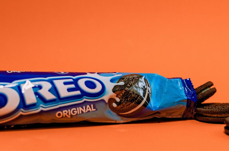 A packet of vegan Oreos in front of an orange background