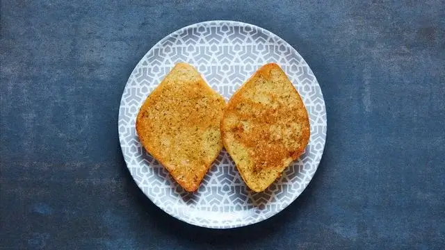 A plate of two slices of garlic bread, part of the Nando's vegan sides