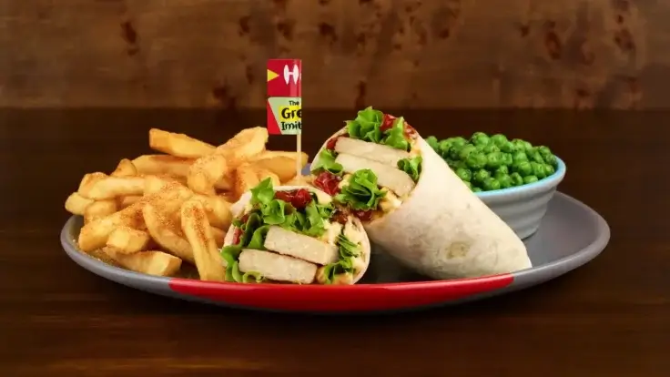 The Great Imitator Wrap from the Nando's vegan menu, plus chips and peas