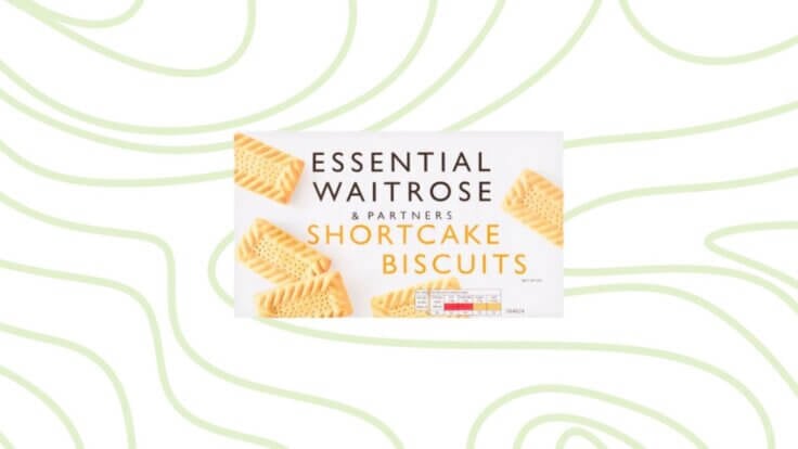 A packet of vegan shortcake biscuits from Waitrose in front of a green background